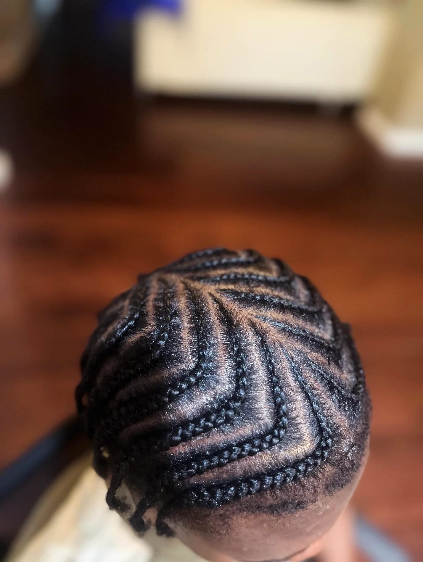 Close-up from above of cornrows braided in a sweeping zig-zag pattern